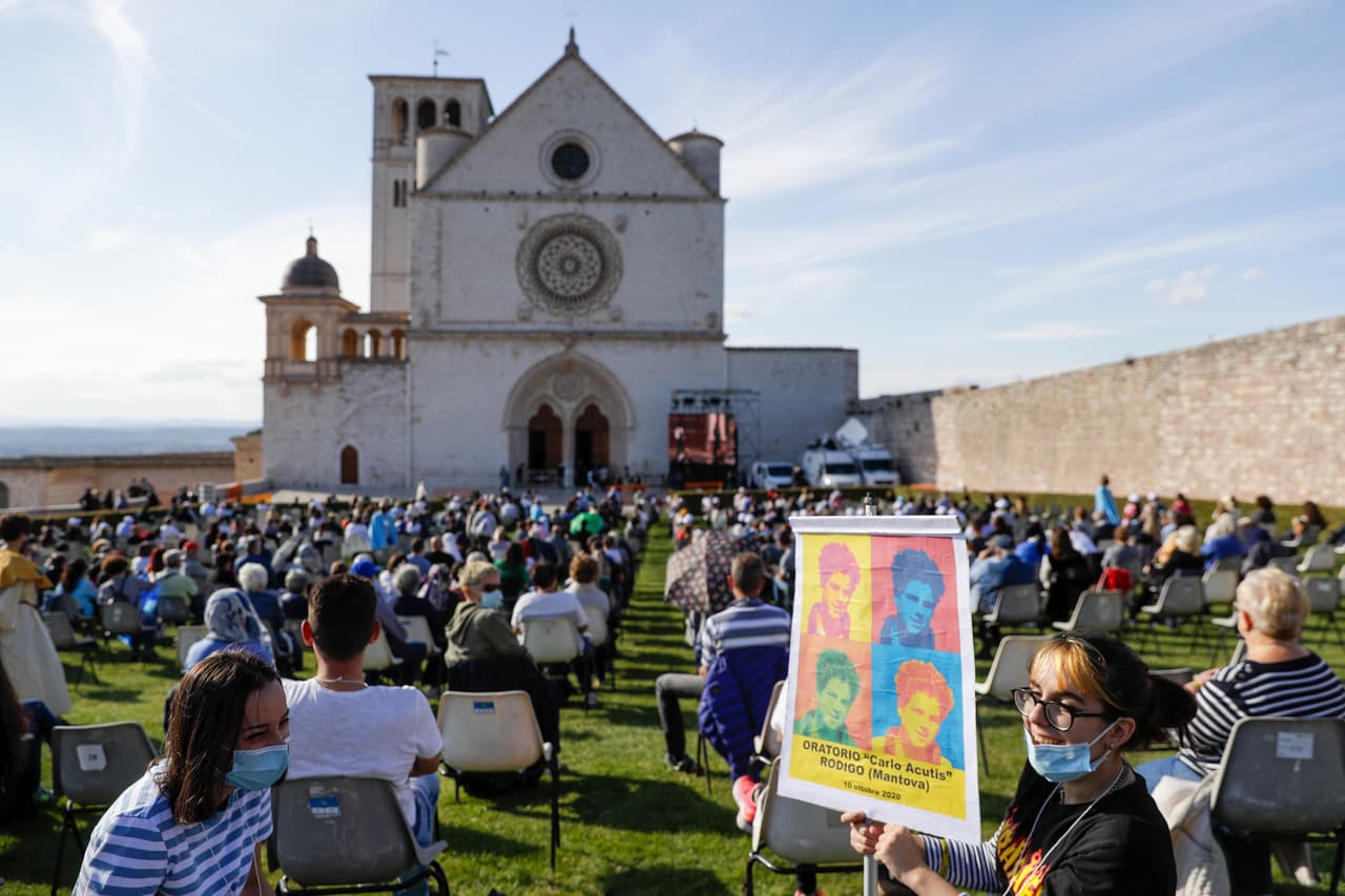 People attend the beatification ceremony of 15-year-old Carlo Acutis, an Italian boy who died in 2006 of leukemia, in front of the St. Francis Basilica, in Assisi, Italy, Saturday, Oct. 10, 2020. (AP Photo/Gregorio Borgia)