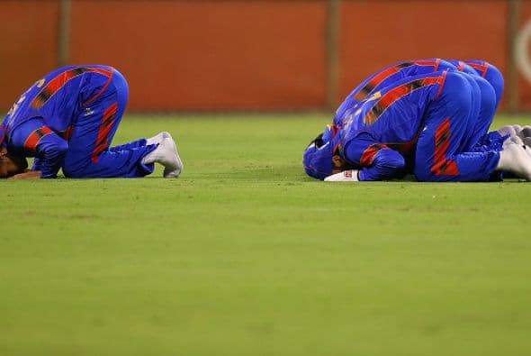 Jugadores de cricket de Afganistán rezan durante el partido frente a Australia durante una gira por ese país.