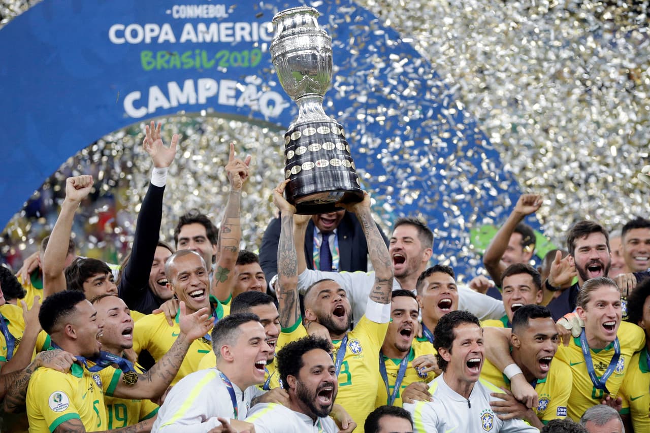 Los jugadores y cuerpo técnico de Brasil con el trofeo en las manos celebran la conquista de su novena Copa América.