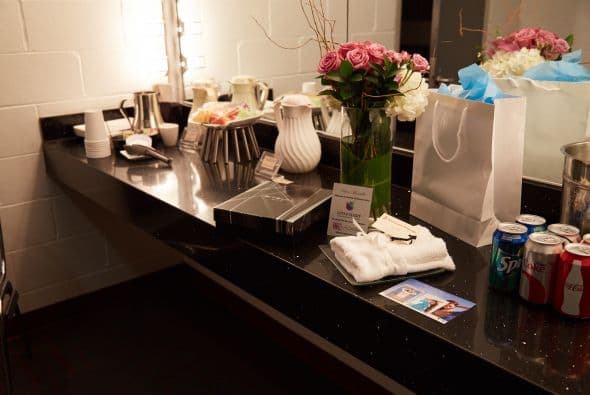 Unas flores y sus regalos destacan frente al espejo.