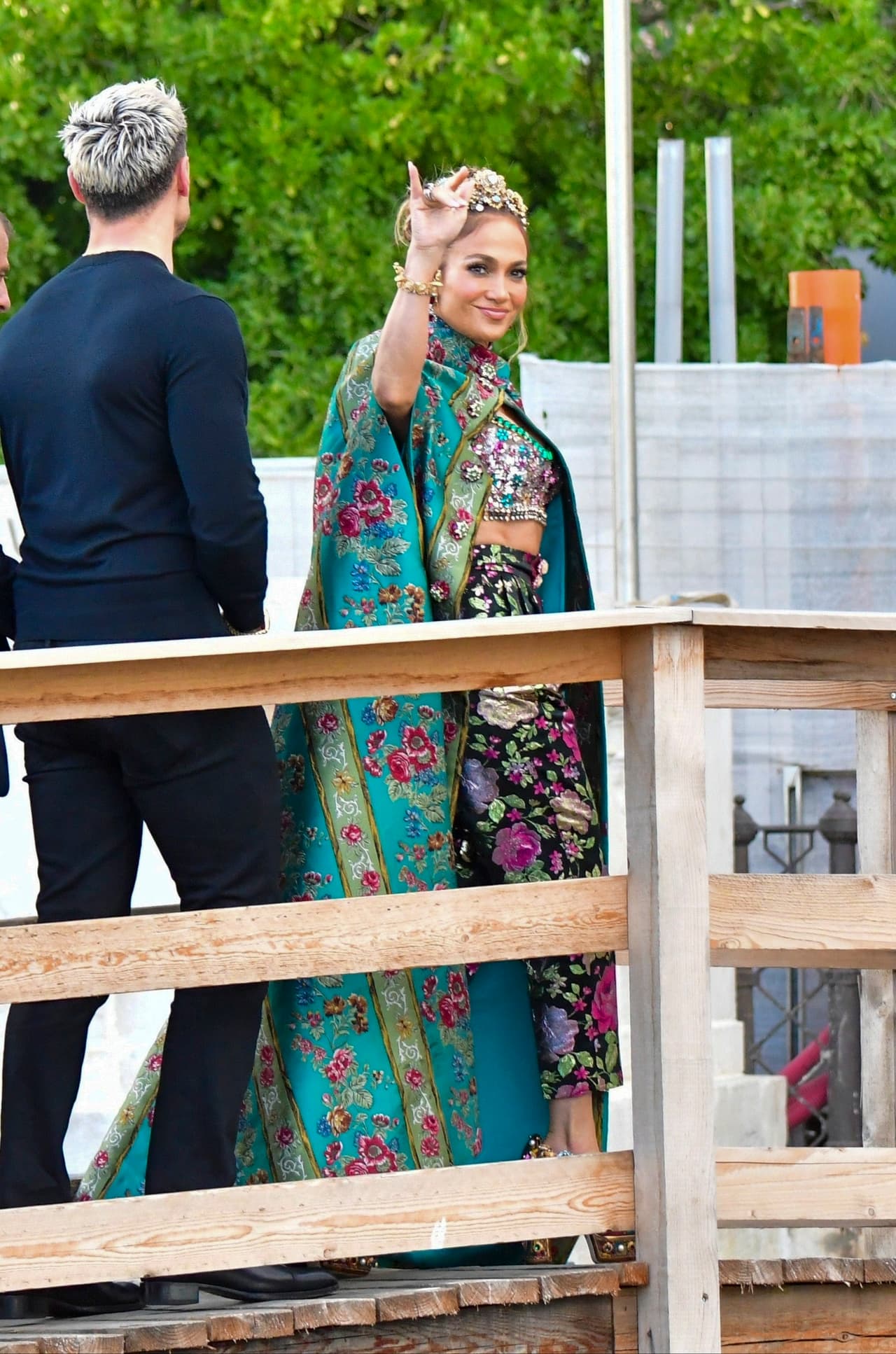 El look lo completó con pantalones de seda negros adornados con rosas y tacones gruesos y brillantes.
<br>