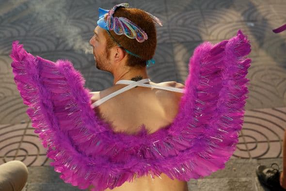 Un participante se sienta en un par de escalones para mostrar al lente de la cámara sus alas de ángel.