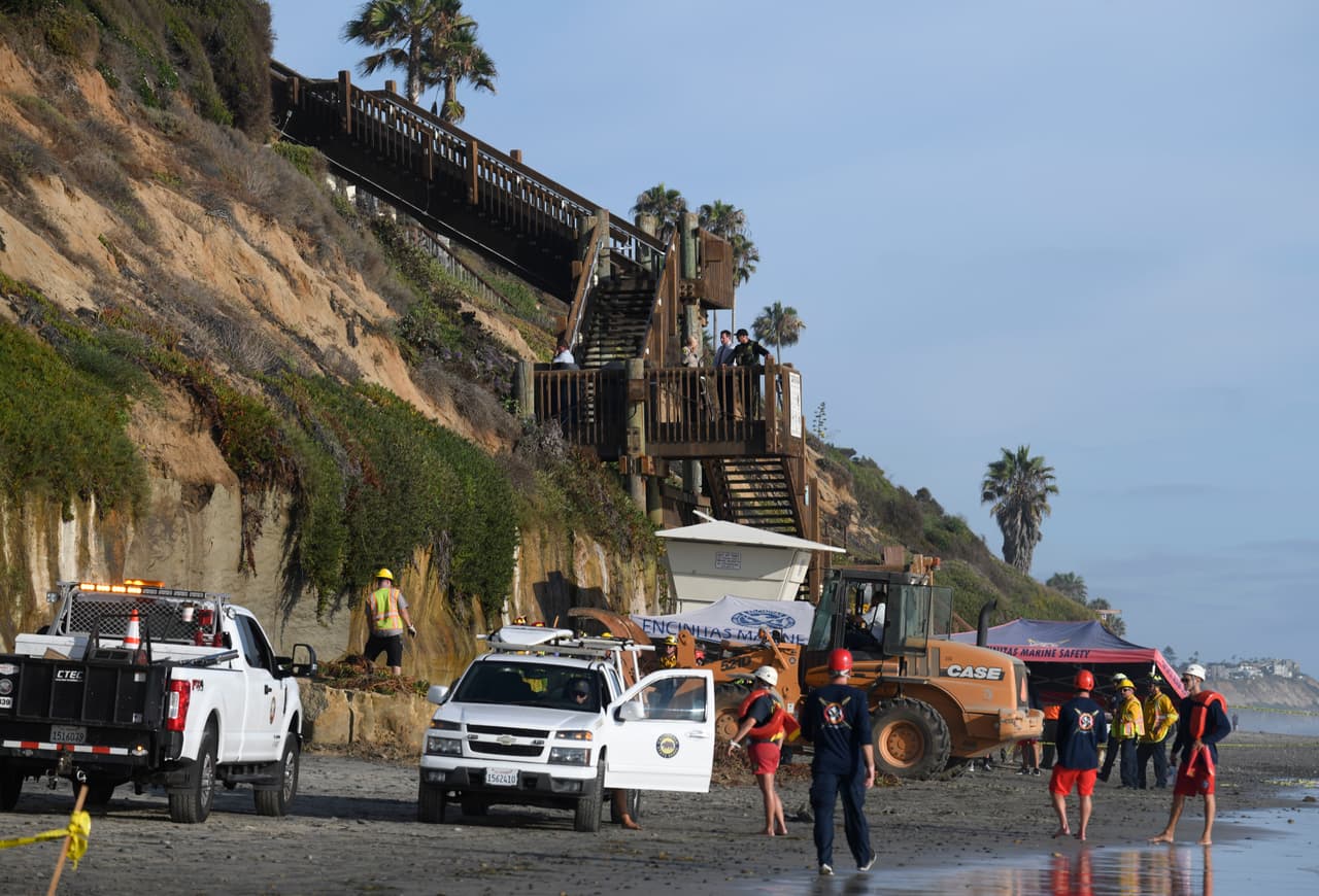 Casi de inmediato equipos de primero auxilios y salvavidas excavaron la zona del derrumbe buscando a las personas que minutos antes disfrutaban de un soleado día de verano en la popular playa surfista.