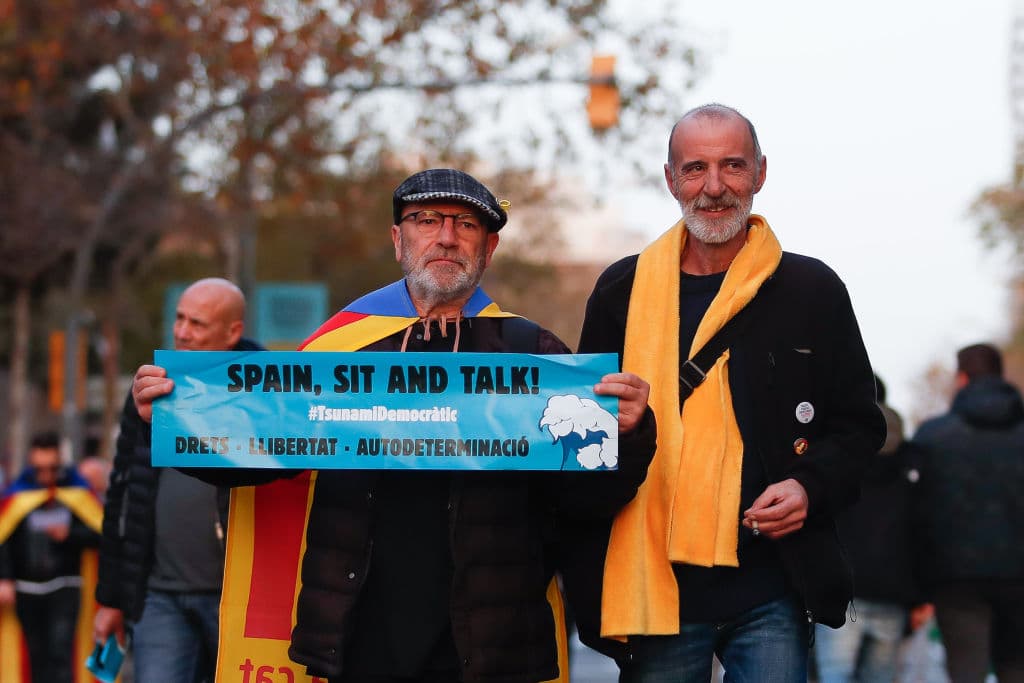 La gente acude al Camp Nou con las cartulinas de 'Spain, sit and talk' y banderas esteladas, de forma pacífica.