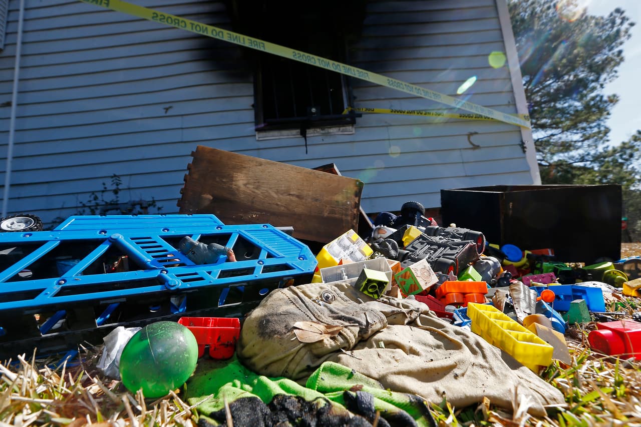 Juguetes y ropa quemada yacían en el jardín de la familia.