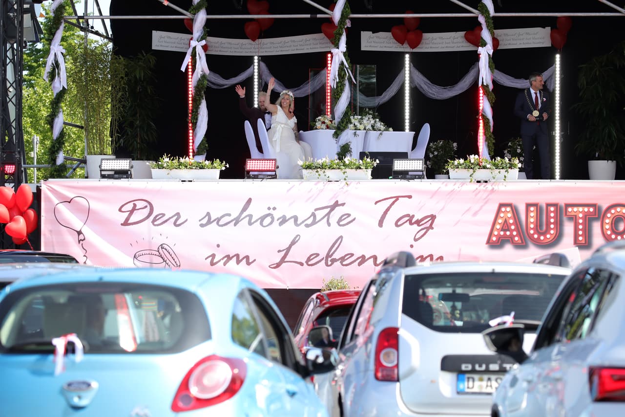 ‘
<b>Autorecepciones’ de bodas. </b>Los novios saludan a los invitados en sus autos en la celebración de su matrimonio en Dusseldorf, Alemania, el 5 de mayo. Ese día hubo fiestas de boda en un autocine adaptado para este fin en la ciudad.