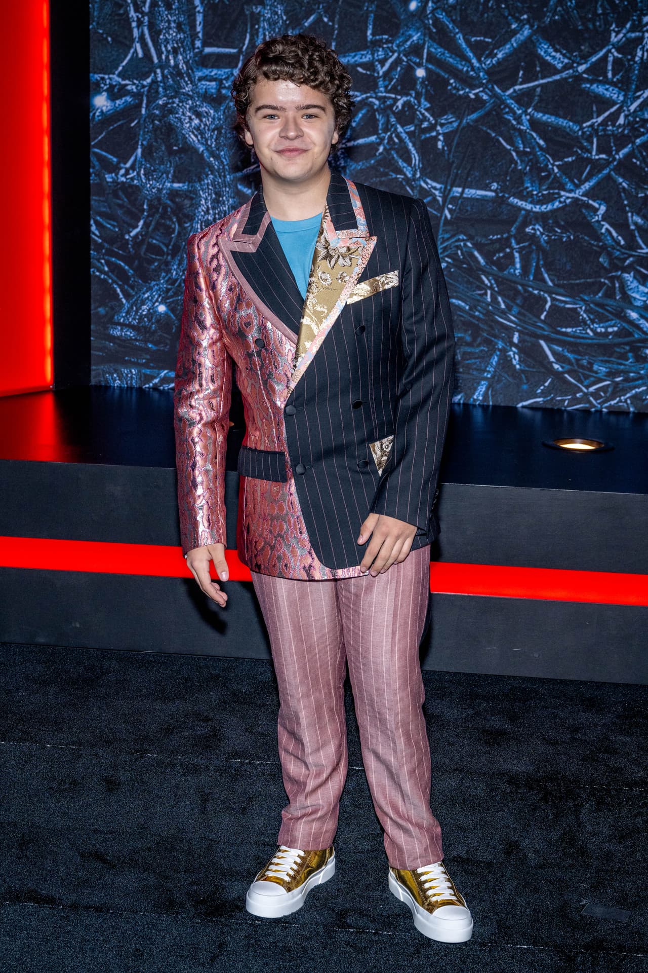 En la vida real, los rulos del actor siguen siendo protagonistas de su aspecto, sólo que la ropa moderna toma el lugar de su look ochentero.