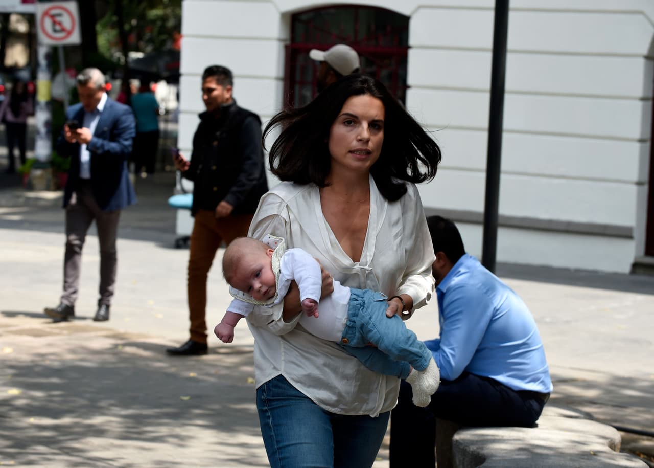 A woman rushes with her baby along the streets after a quake rattled Mexico City on September 19, 2017. A powerful earthquake shook Mexico City on Tuesday, causing panic among the megalopolis' 20 million inhabitants on the 32nd anniversary of a devastating 1985 quake. The US Geological Survey put the quake's magnitude at 7.1 while Mexico's Seismological Institute said it measured 6.8 on its scale. The institute said the quake's epicenter was seven kilometers west of Chiautla de Tapia, in the neighboring state of Puebla. / AFP PHOTO / Alfredo ESTRELLA (Photo credit should read ALFREDO ESTRELLA/AFP/Getty Images)