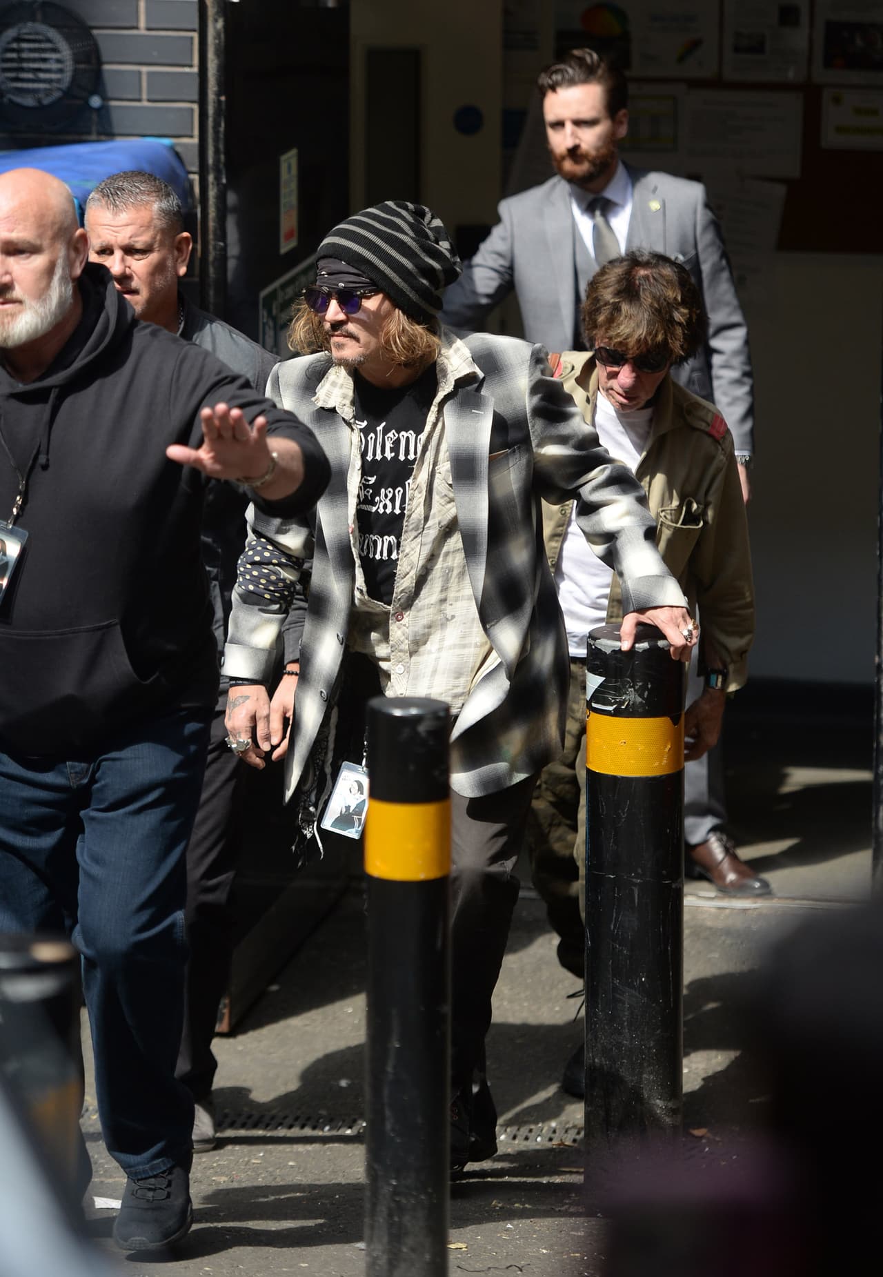 Depp vestía una chaqueta deportiva a cuadros en blanco y negro sobre jeans y zapatos oscuros. 
<br>