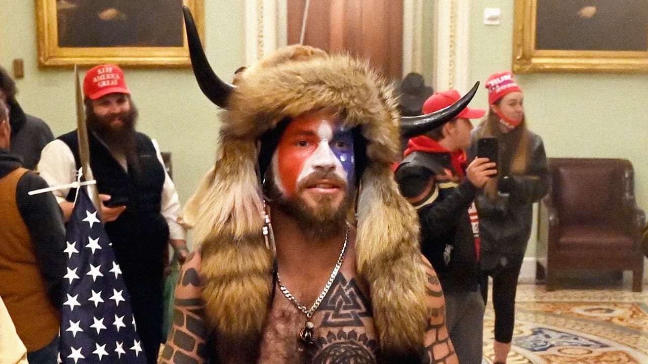 <b>Jake Angeli.</b> También es conocido como ‘Q Shaman’ por ser uno de los más visibles 
<a href="https://www.univision.com/noticias/teorias-conspiracion-son-peligrosas-las-teorias-de-qanon-mas-alla-de-las-redes-sociales-preguntas-y-respuestas-sobre-este-movimiento"><u>propagadores de las teorías de conspiración de la organización QAnon</u></a>. Su nombre real es Jacob Anthony Chansley y ha sido visto en múltiples mítines pro-Trump en Arizona desde 2016. Fue uno de los más fotografiados dentro del capitolio el 6 de enero y las autoridades lo capturaron tres días después. Según el Departamento de Justicia, 
<a href="https://www.justice.gov/usao-dc/pr/three-men-charged-connection-events-us-capitol"><u>Chansley enfrenta un cargo por entrar o permanecer en un edificio restringido sin autoridad legal y otro por entrada violenta y conducta desordenada en los terrenos del Capitolio</u></a>. 
<a href="https://www.univision.com/noticias/politica/en-fotos-partidarios-de-trump-entran-a-la-fuerza-al-capitolio-de-estados-unidos-protesta-donald-trump-joe-biden-elecciones-2021-fotos"><u>Vea aquí las fotografías del asalto de partidarios de Trump al Capitolio de Estados Unidos</u></a>