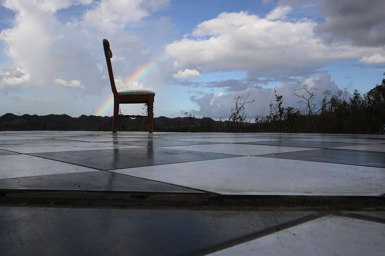 COROZAL, PUERTO RICO - OCTOBER 02: A rainbow is seen behind a chair that sits on the floor of what is left of a house that was blown away by Hurricane Maria, October 2, 2017 in Corozal, Puerto Rico. People continue to deal with having no gas, electricity or water in the aftermath of the storm. (Photo by Joe Raedle/Getty Images)