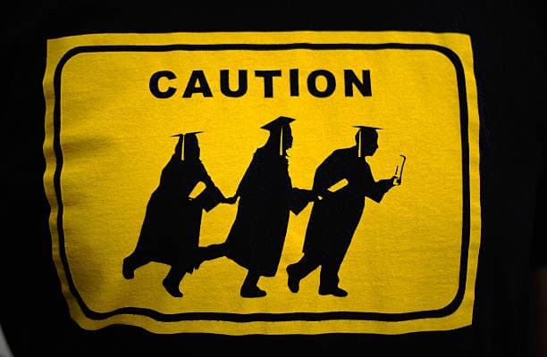 El logotipo de esta playera modificó la imagen creada por la Patrulla Fronteriza de una familia indocumentada cruzando una carretera, por la de tres graduados de universidades.