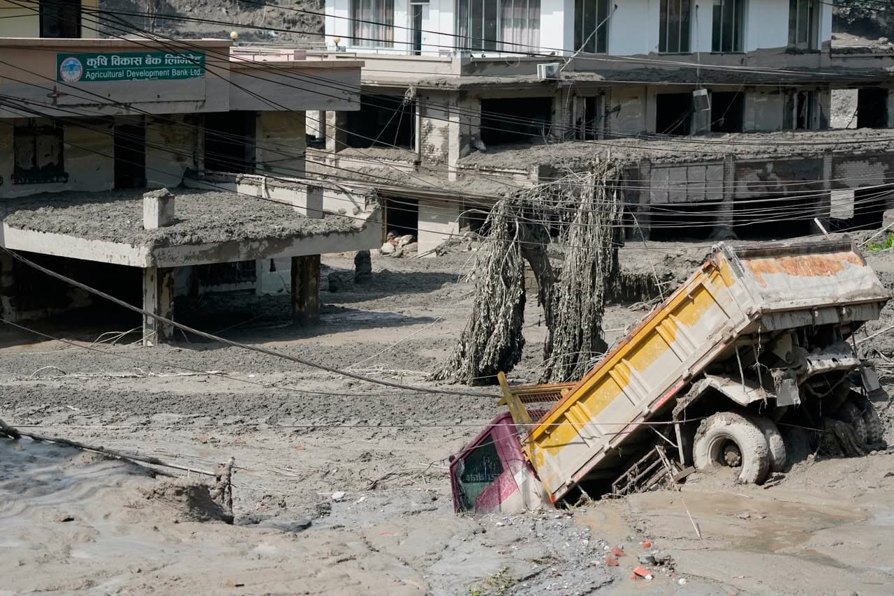 En esta foto, un tractocamión es absorbido por el lodo de la inundación.