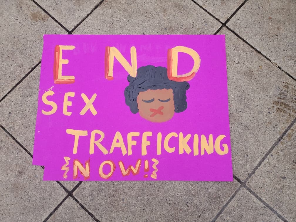El póster dice, "Poner fin al tráfico sexual ahora".