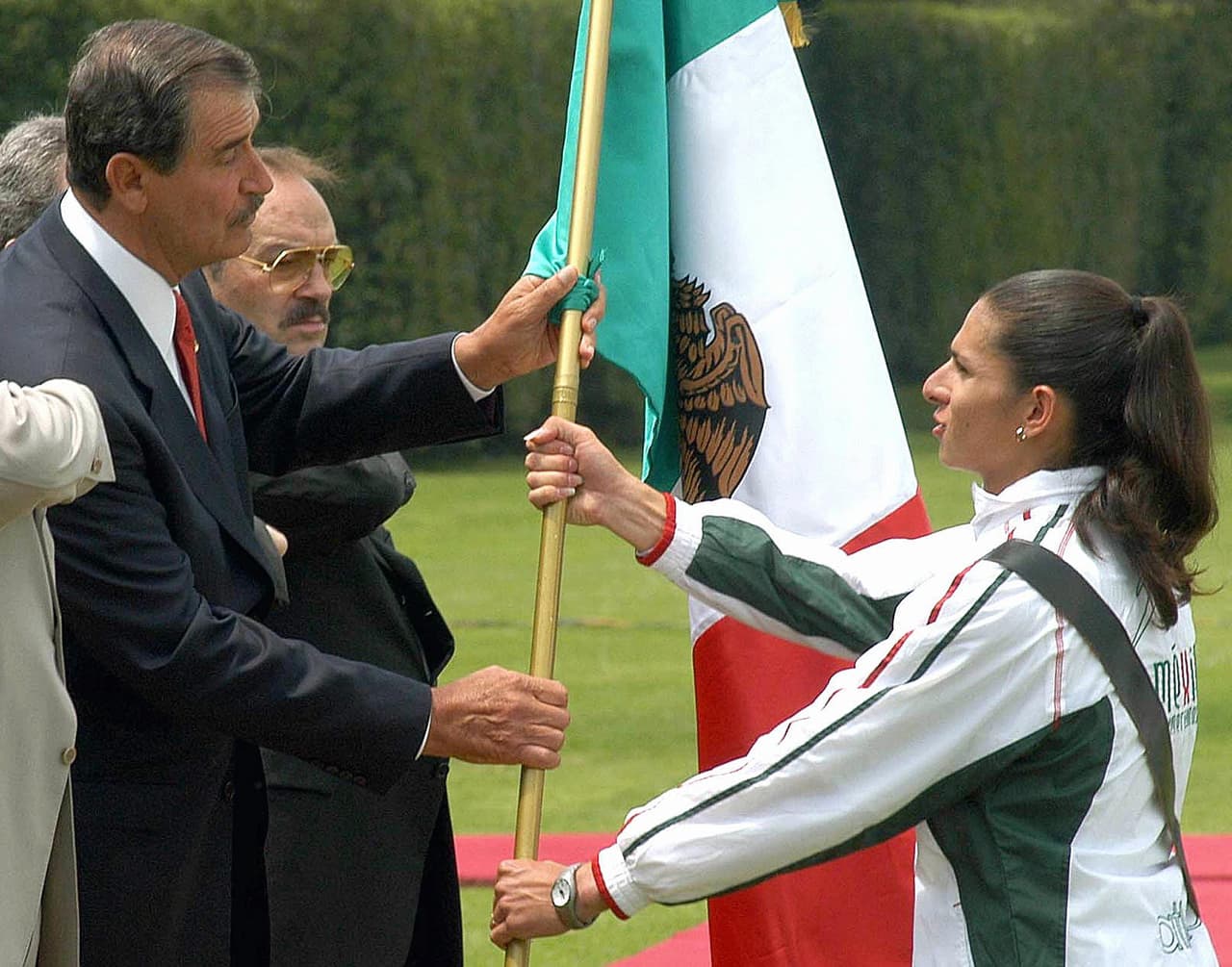 Ana Gabriela Guevara recibe la bandera mexicana que acompañará a la delegación de México en los Juegos Panamericanos de Republica Dominicana, de las manos del entonces presidente Vicente Fox, en 2003.