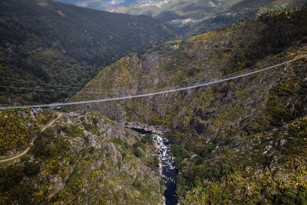 El puente Arouca 516, ubicado en la ciudad de Arouca -en el distrito de Aveiro, Portugal, es el puente colgante peatonal más largo del mundo al tener una longitud de 1693 pies y una elevación de 575 pies.