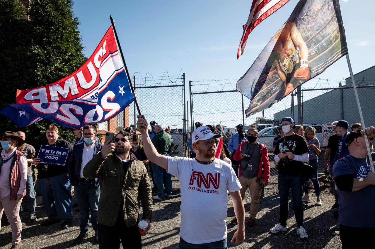 Los partidarios del presidente Donald Trump se reúnen fuera de una conferencia de prensa donde el abogado del presidente, Rudy Giuliani, habló con los medios de comunicación en el estacionamiento trasero una empresa de jardinería.