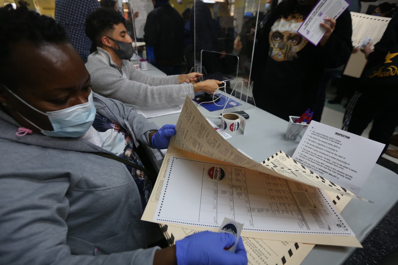 Trabajadora electoral verifica la papeleta antes de entregarla al votante en la escuela PS 173 de Washington Heights, Manhattan