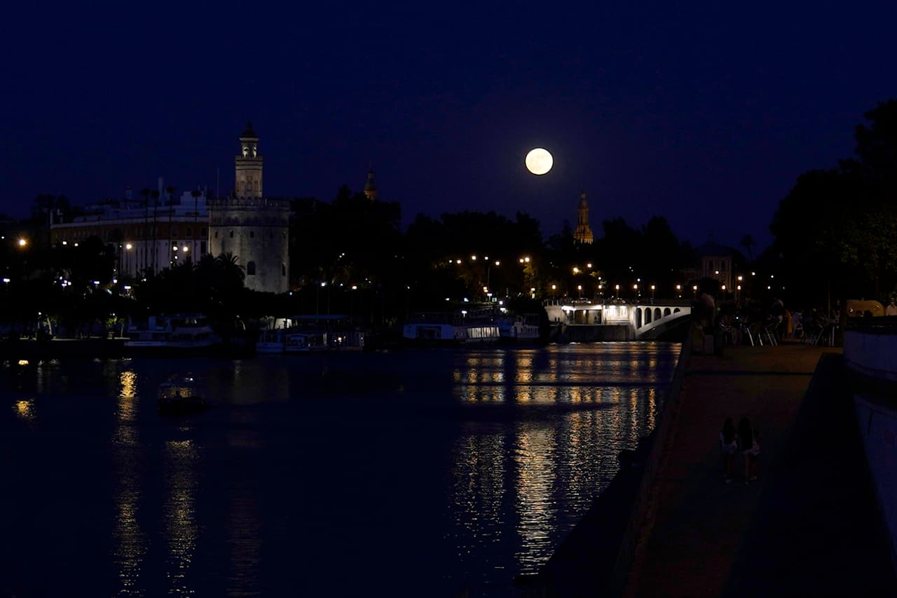 Una hermosa imagen de la 'Luna de fresa' sobre el río Guadalquivir y la Torre del Oro, en Sevilla, 
<a href="https://www.univision.com/temas/espana">España</a>.