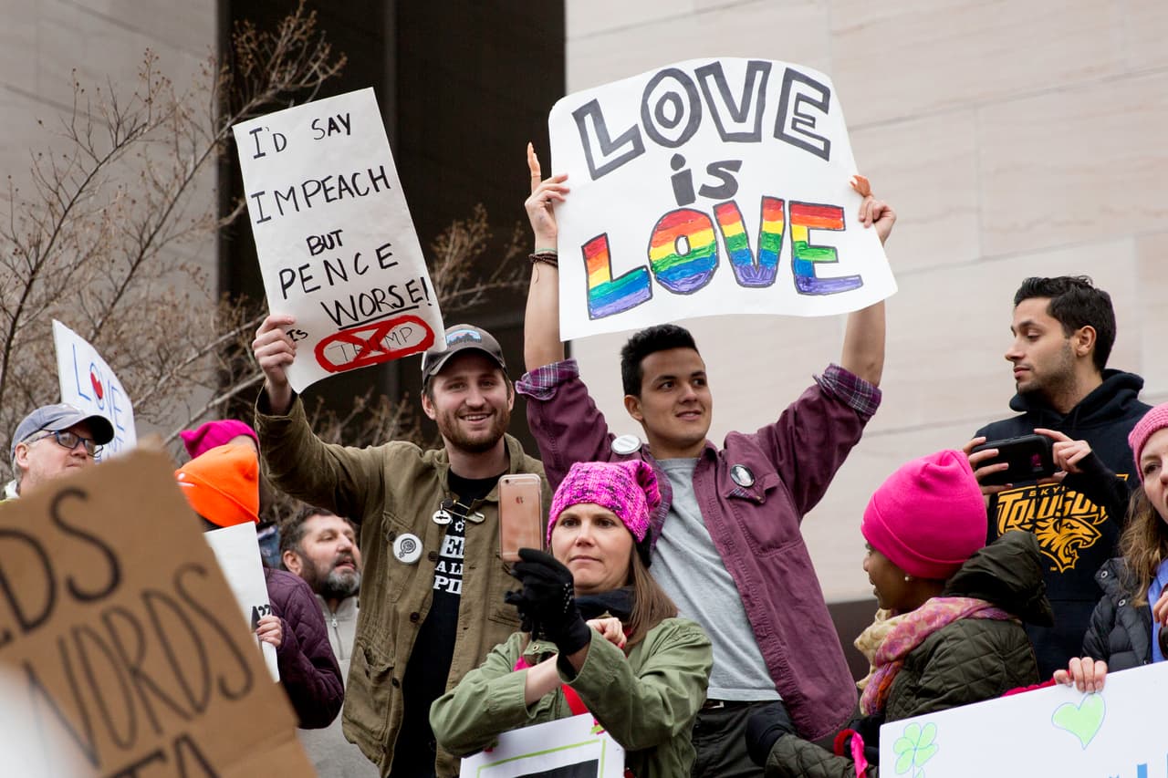 "Diría que lo impugnáramos", dice esta pancarta refiriéndose a Donald Trump, "pero el vicepresidente Pence es peor". Al lado otra que reza: "Amor es amor", en apoyo a la comunidad LGBT.