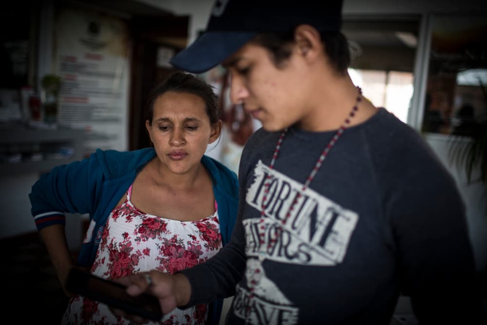 Ana y Luis usan por unos minutos su celular. Intentan contactar por Facebook con su familia en Honduras. En el centro limitan el uso de los teléfonos a 20 minutos diarios.
