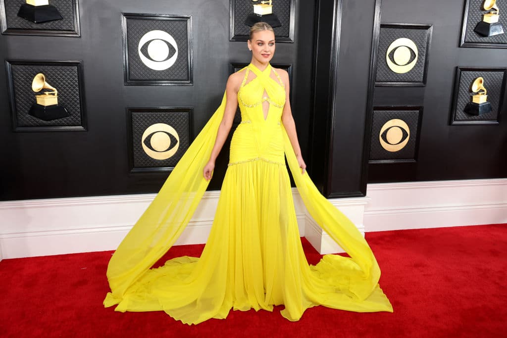 <h2 class="cms-H2-H2">Kelsea Ballerini</h2>
<br>La cantante y compositora de música country dejó de lado los tonos sobrios y prefirió usar un vestido en color amarillo, de Prabal Gurung. La capa larga le dio un toque muy femenino.