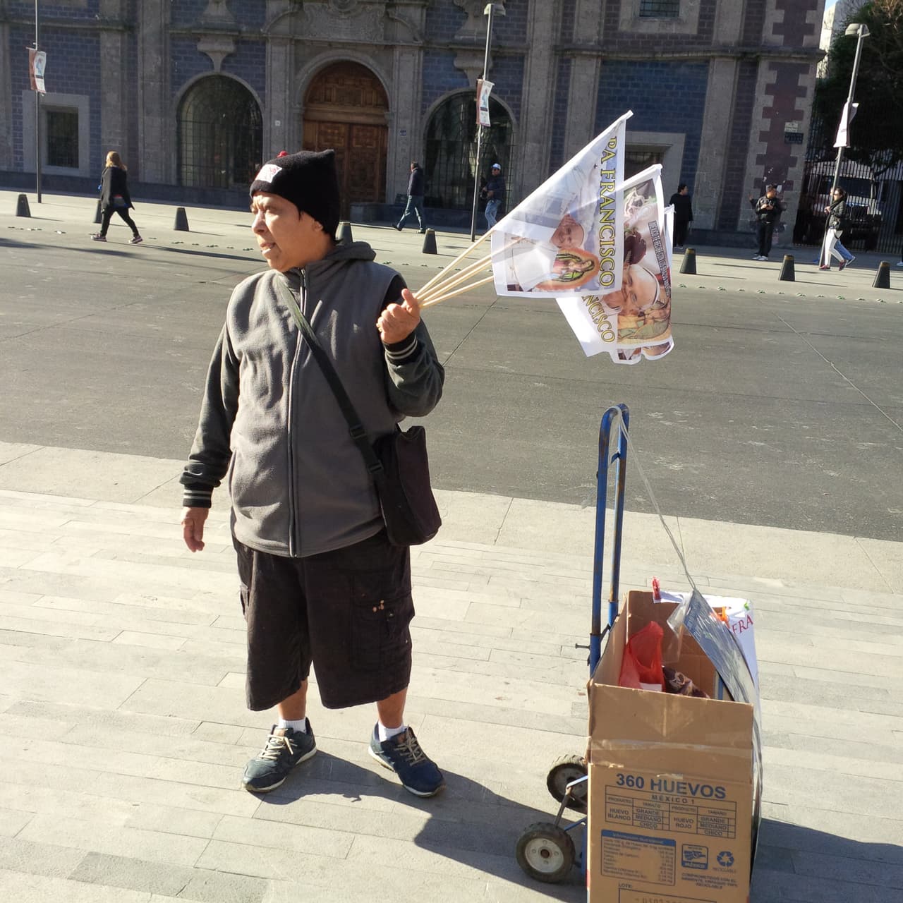 Un vendedor ofrece banderas con la imagen del Papa en el centro de la Ciudad de México.