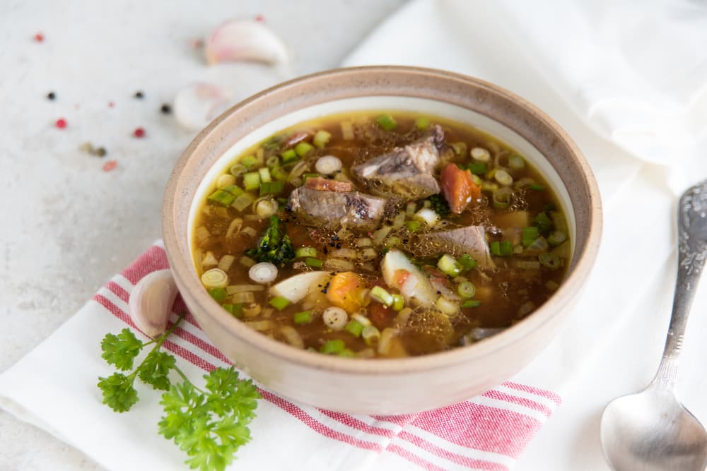 Sopa de osobuco con gremolata. La sopa lleva ternera, ese es el osobuco se trata de un corte de carne ovalado que tiene un hueso redondo en el centro. Es una receta con sabor intenso, entre ácido y fresco debido a que contiene gremolata.