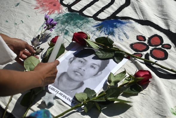 Un grupo de estudiantes colocó veladoras y flores sobre los retratos de los estudiantes desaparecidos.