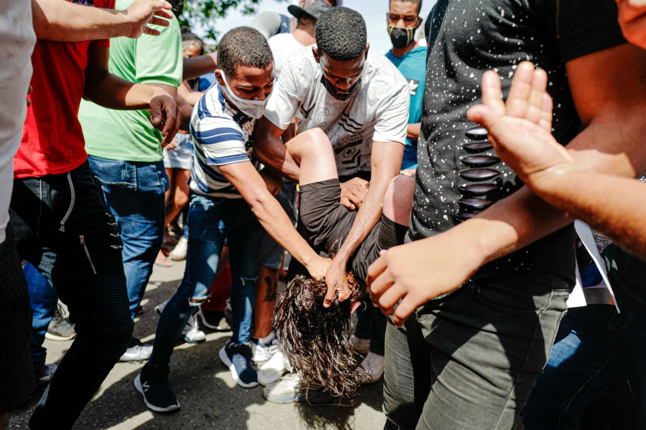 En esta imagen se puede observar como un hombre es tomado del cuello en medio de las protestas.
