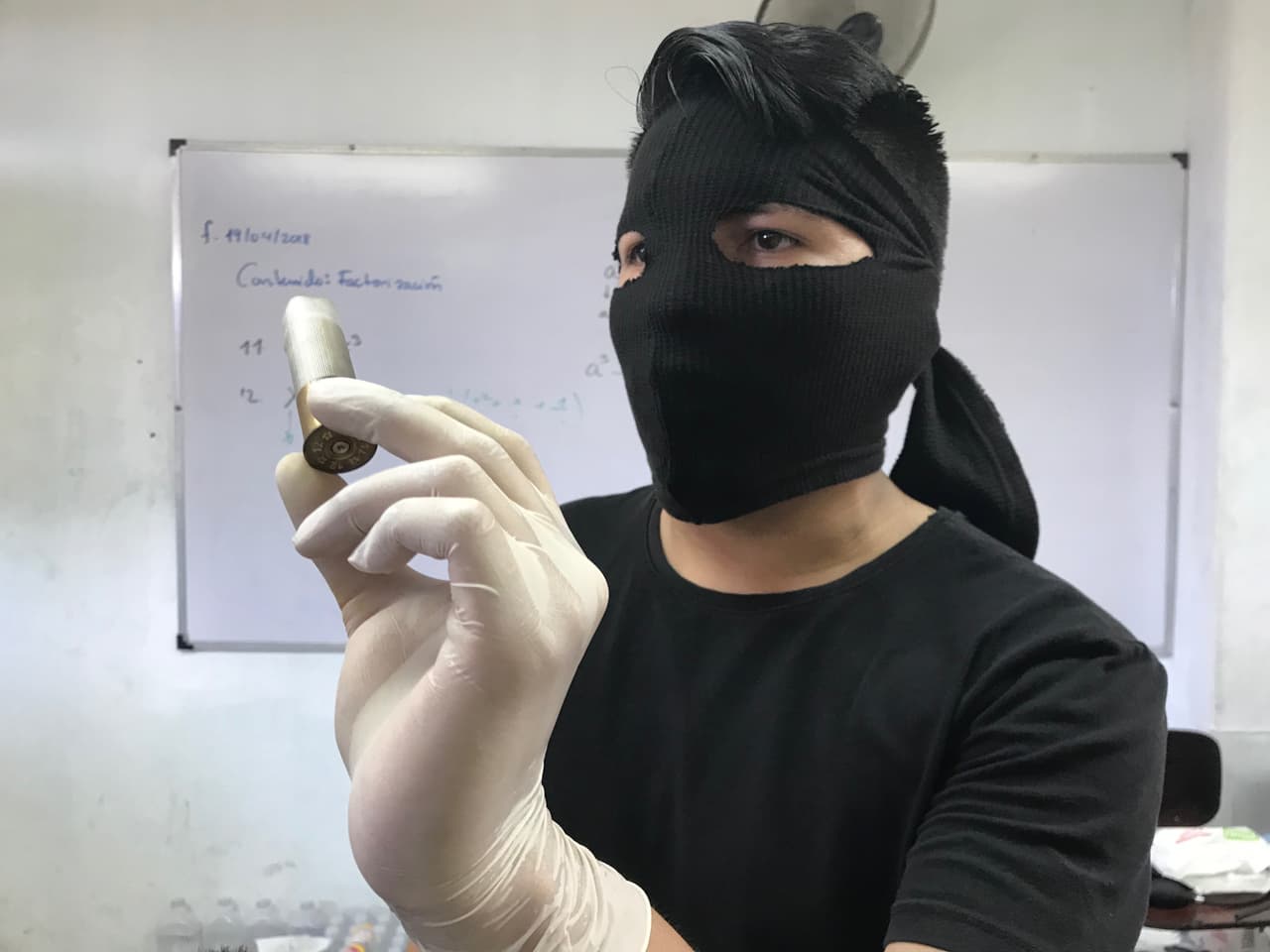 A masked Upoli student show bullet cartridge from police attack on the csampus on Sunday night. Tim Rogers/Univision