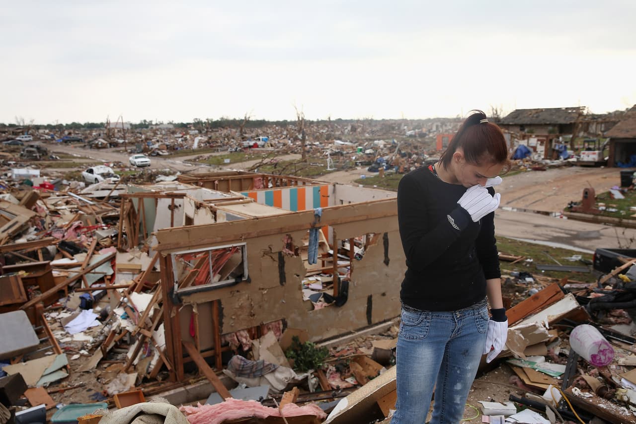 Sabrina Mitchell se lamenta, mientras busca sus pertenencias en los escombros de la que fuera su casa, después del paso de un tornado el 24 de mayo de 2013 en Moore, Oklahoma.