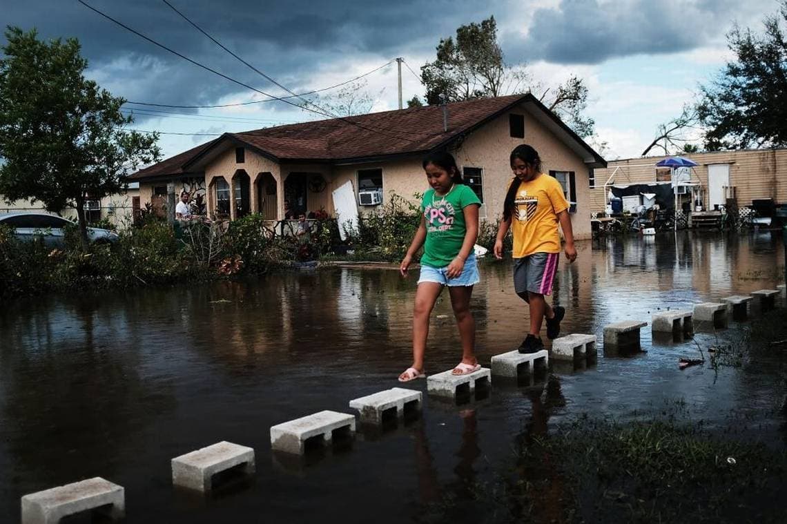 Niños caminan por las calles inundadas de Immokalee, especialmente afectada por el paso del huracán Irma.
<br>