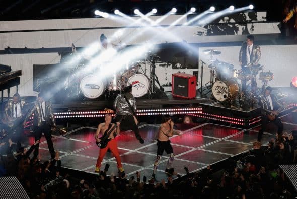 Un cuidado estilismo retro, una banda llena de energía y una particular mezcla de soul y rock sirvieron al cantante Bruno Mars para cautivar a la millonaria audiencia del Super Bowl durante el descanso de la gran cita anual del fútbol americano. Mars, de sólo 28 años y sobre quien planeaba la duda de si sería capaz de enfrentarse a un escenario de tal calibre, optó por un show directo y contundente. Tras una breve introducción a cargo de un coro de niños, un espectacular solo de batería sirvió para abrir el fuego y dar paso rápidamente al gran éxito "Locked Out of Heaven". Impecablemente vestido con una chaqueta dorada, despachó el tema junto a una banda con una amplia sección de viento que se lució en las coreografías. Sin más dilación, Mars descargó su segundo hit, "Treasure", y a continuación demostró su capacidad para fusionar el soul, el pop y el rock integrando en su espectáculo a los Red Hot Chili Peppers. La banda de Anthony Kiedis y Flea puso a saltar a todo el estadio Metlife con su clásico "Give it Away". Los rockeros californianos, a pecho descubierto como manda la tradición, solo necesitaron un par de minutos para demostrar que siguen en buena forma y ceder de nuevo el protagonismo a Mars.