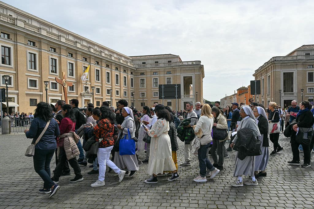 Fieles y peregrinos llevan una cruz de madera hacia la plaza de San Pedro tras la muerte del papa Francisco este 21 de abril de 2025.