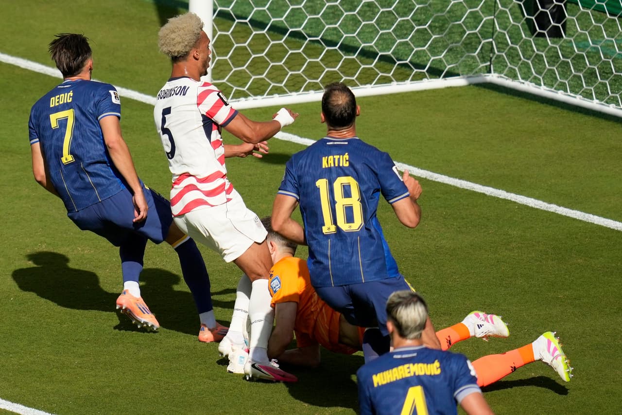 Antonee Robinson (5), de Estados Unidos, choca con el portero de Bosnia, Nikola Vasilj (1), durante el partido de dieciseisavos de final de la Copa del Mundo entre Estados Unidos y Bosnia en Santa Clara, California, cerca de San Francisco, el miércoles 1 de julio de 2026.