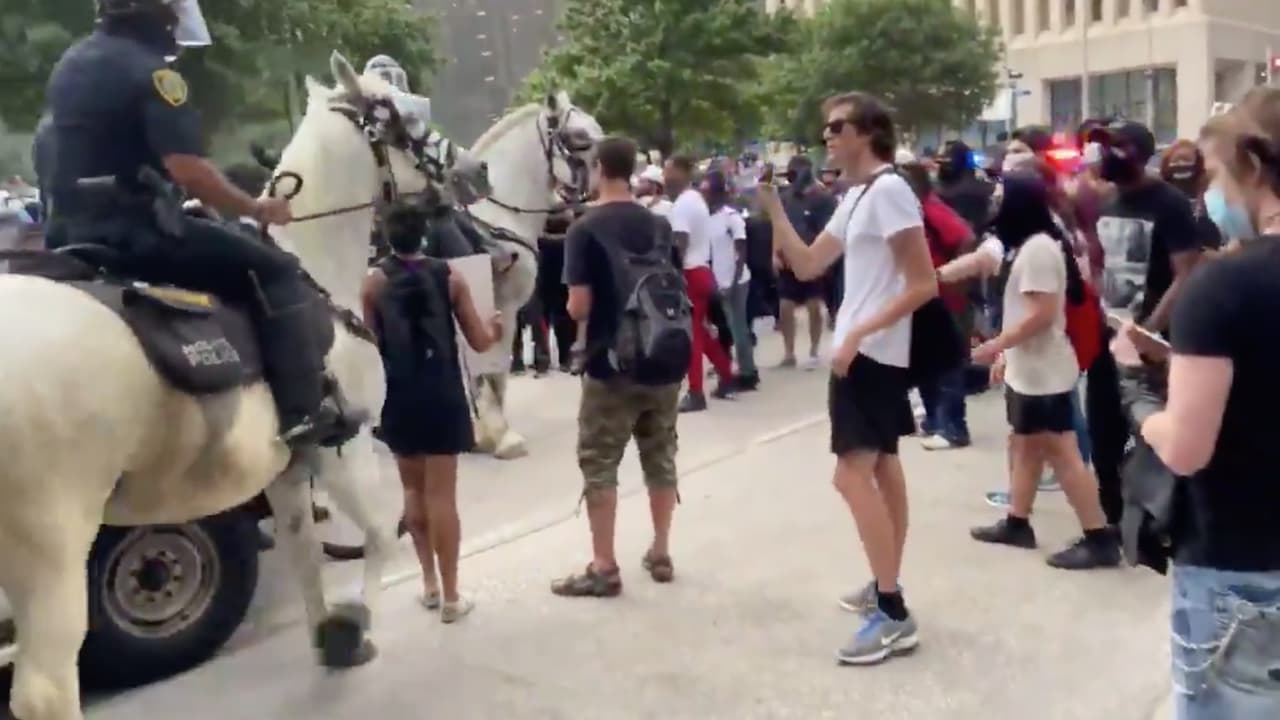 La policía montada se acercó al área y se ve a la mujer parada.