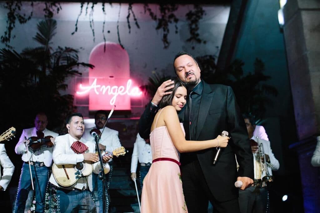 Padre e hija fundidos en un cariñoso abrazo mientras los invitados los celebraraban con porras y aplausos.