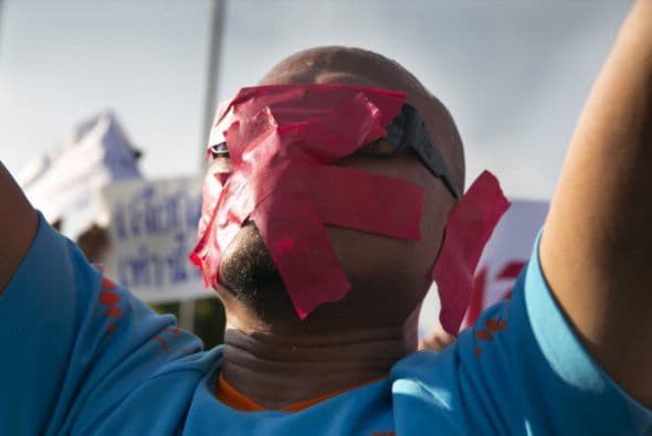 Este manifestante ha cubierto con cinta buena parte de su rostro, en contra del golpe de Estado militar en Tailandia.