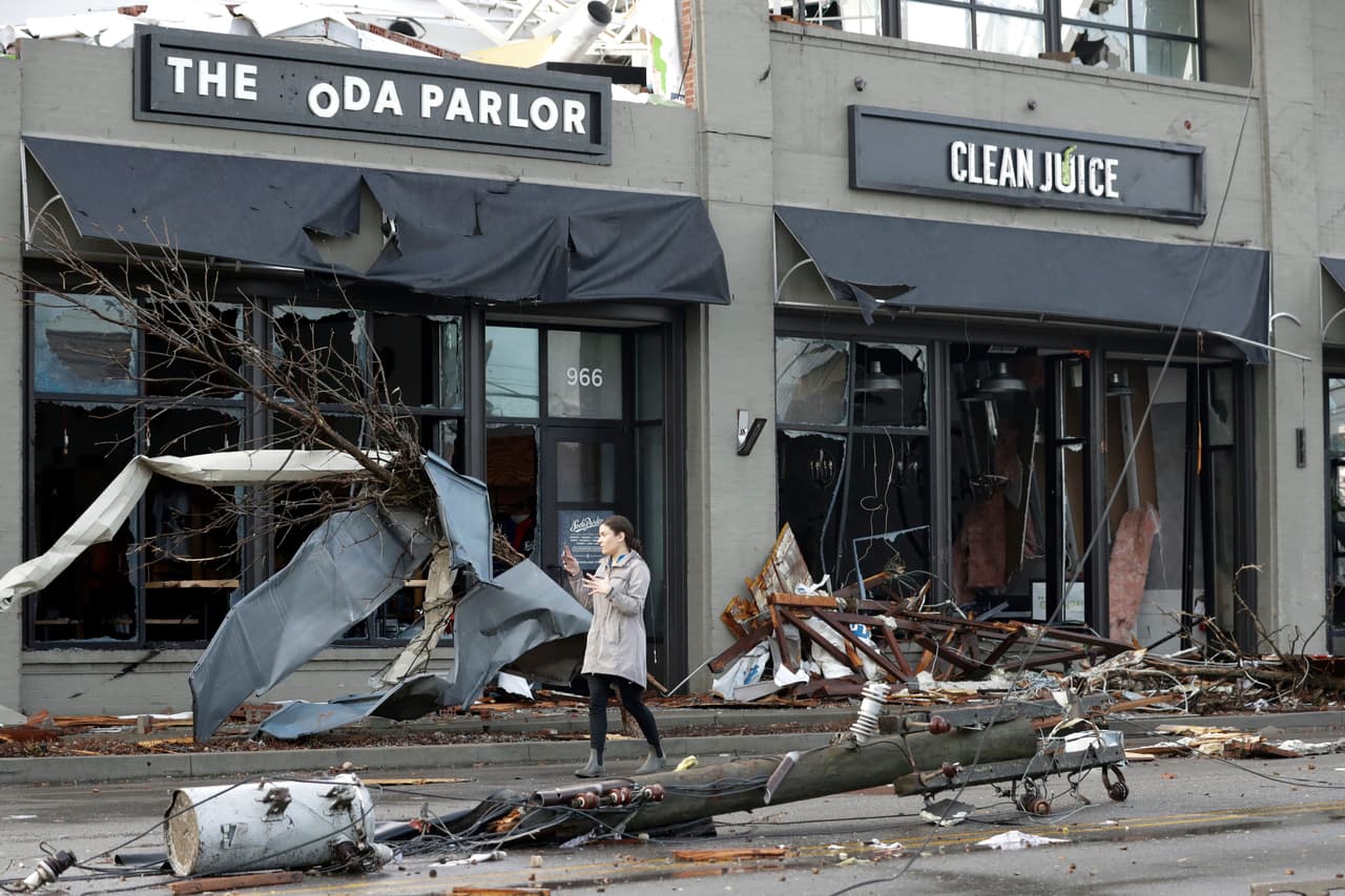 Una mujer camina por una calle cubierta de escombros en la ciudad de Nashville, Tenn. (AP Photo/Mark Humphrey)Un
