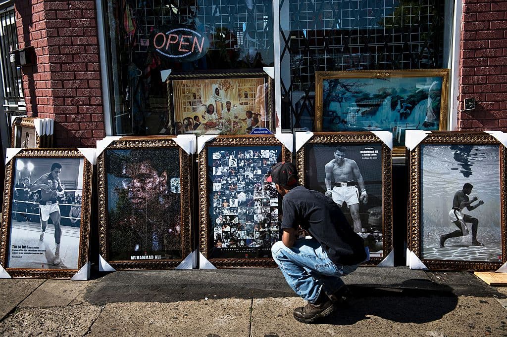 Alonzo Malone Jr. observa las imágenes de Ali que han revestido las calles de su cuna. Se espera que cerca de 15,000 personas participen en el acto fúnebre final previsto para el 10 de junio. Foto de Brendan Smialowski para AFP/Getty.
