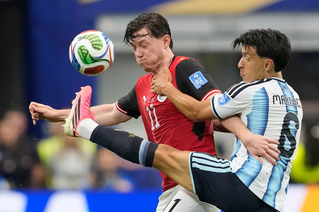 Michael Gregoritsch de Austria pelea el balón con Valentin Barco de Argentina.