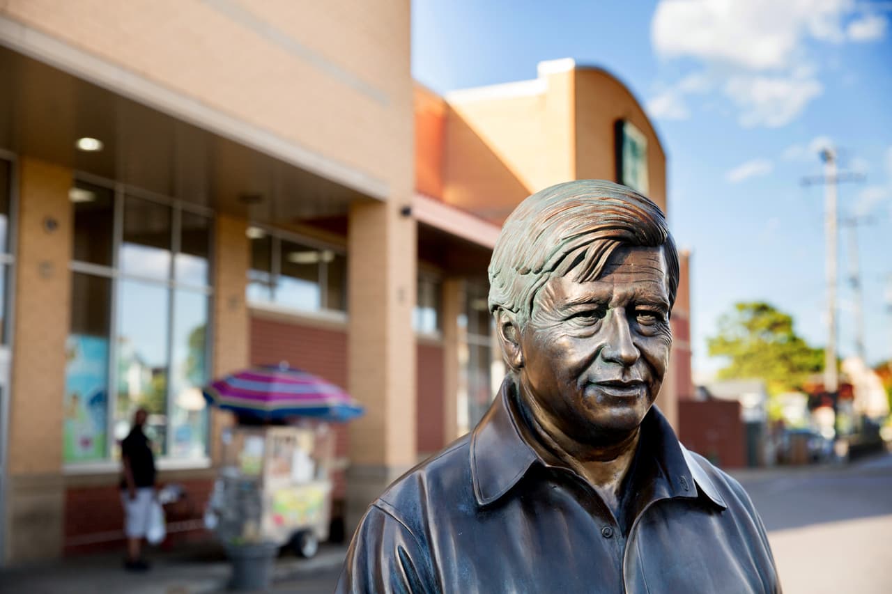 Una figura de bronce de César Chávez al frente de un gran mercado de productos tradicionales mexicanos. Junto a la estatua, se puede leer una frase que el líder campesino dedicó a la ciudad: "No podemos buscar logros para nosotros mismos y olvidarnos del progreso y la prosperidad para nuestra comunidad".