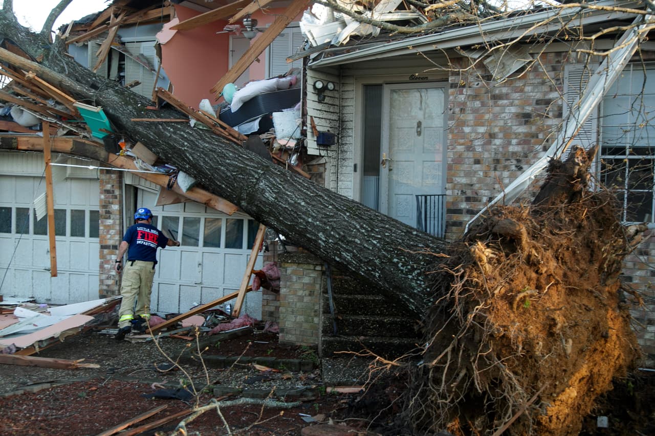 Un bombero revisa esta residencia afectada por los tornados en el vecinario de Walnut Ridge, en Little Rock, Arkansas.