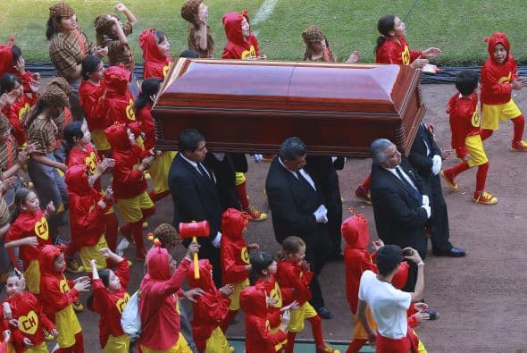 Los niños escoltan a su ídolo mientras la gente aplaude.