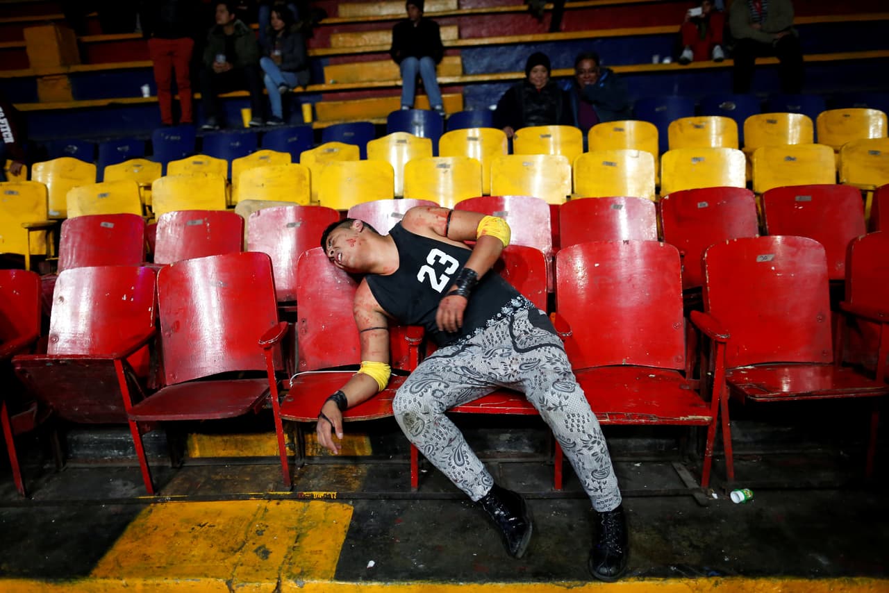 El luchador Junior Malkriado cae adolorido en un asiento durante una lucha extrema. (Foto de Carlos Jasso/Reuters)
