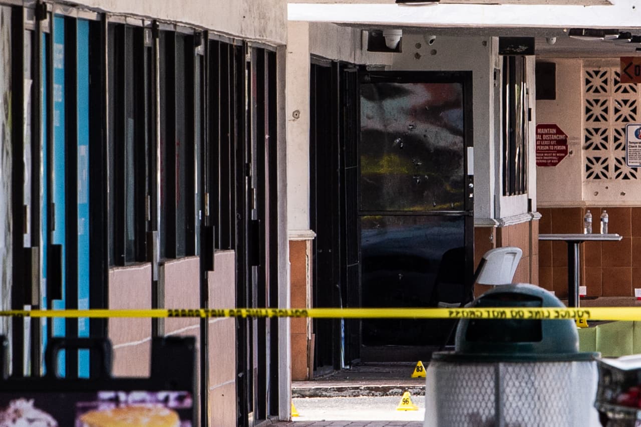 Se ven agujeros de bala cerca de las puertas de un club de billar que fue alquilado para un concierto, después de que tres hombres armados mataron a dos personas e hirieron al menos a 20 personas durante la noche en el condado de Miami Dade.