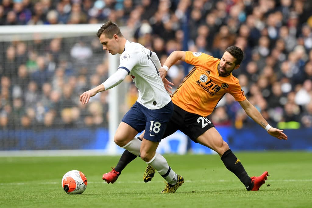 Giovani Lo Celso del Tottenham Hotspur se ve presionado por Joao Moutinho de los Wolves.