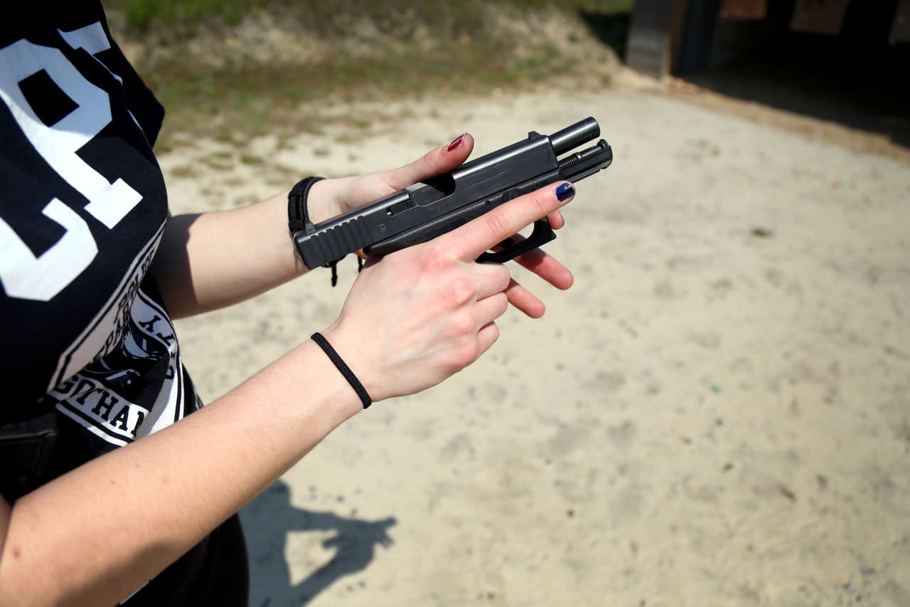 Macklin da una demostración de cómo disparar una pistola en el campo de tiro de la tienda.