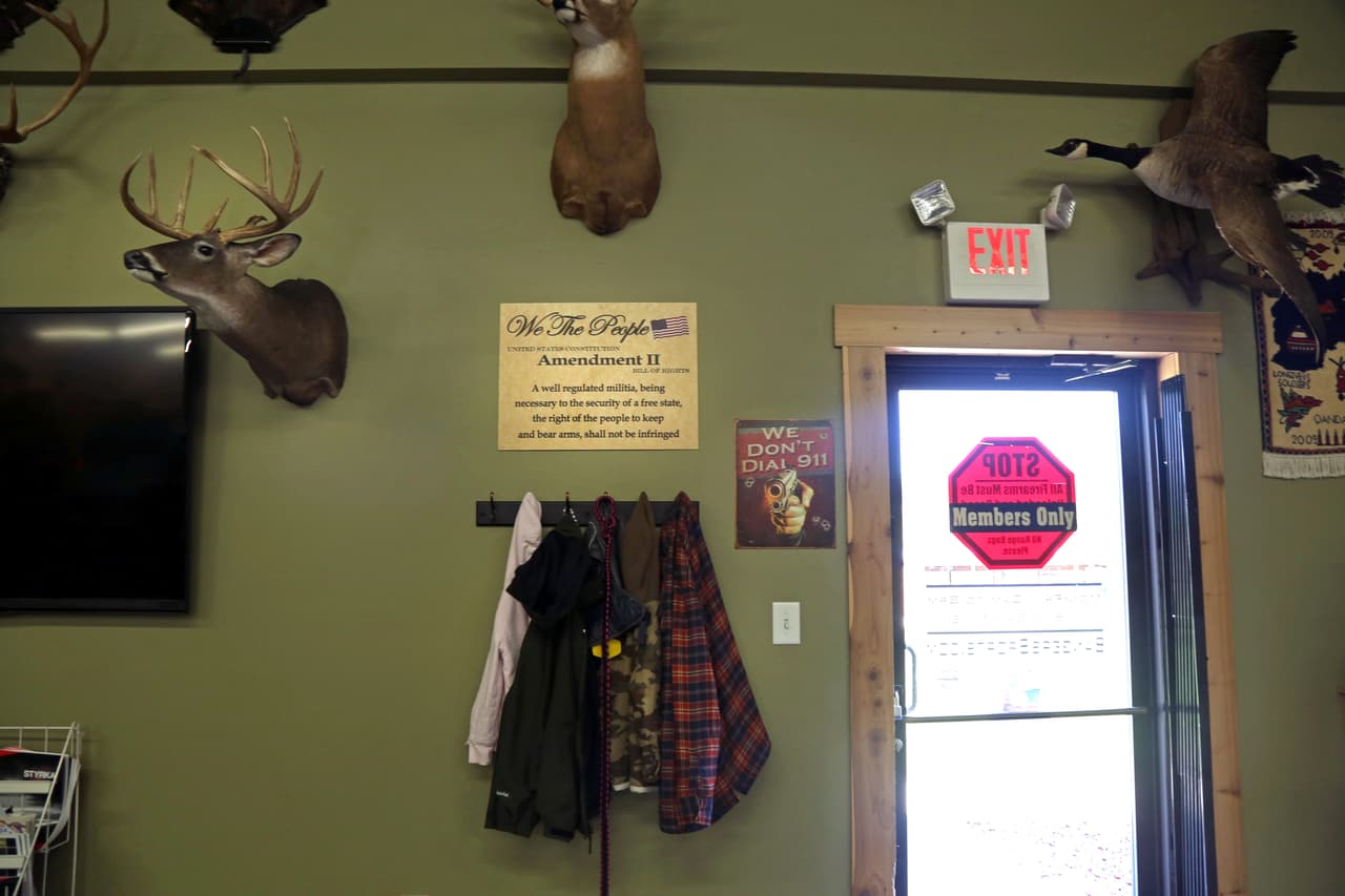 A la salida de la tienda para ir al campo de tiro un letrero dice: "Nosotros, el Pueblo de los Estados Unidos: Enmienda II, Carta de Derechos: Siendo necesaria una milicia bien ordenada para la seguridad de un estado libre, no se violará el derecho del pueblo a poseer y portar armas". A su lado otro letrero dice: "Nosotros no llamamos al 911".
